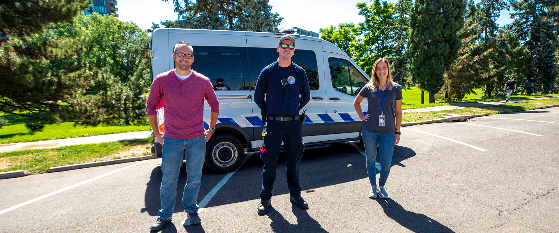 Photo illustrating the International Crisis Response Association's focus, three members of the Denver Crisis Response Team stand smiling in front of a mobile support van.